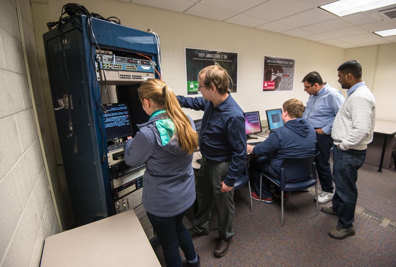 Faculty and students working on computer and server